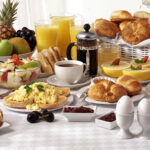 Breakfast,buffet,table,filled,with,assorted,foods,savoury,sweet,pastries,hot,and,cold,drinks
