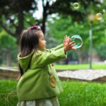 selective photo of a girl holding bubbles